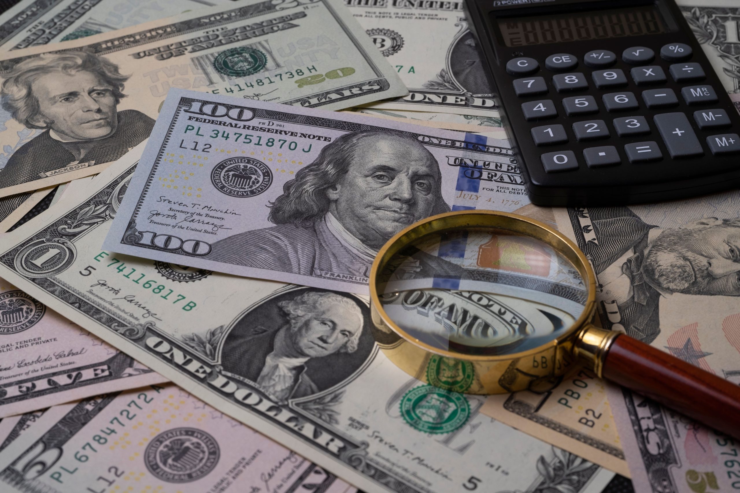 Billets avec loupe et calculatrice pour analyse financière