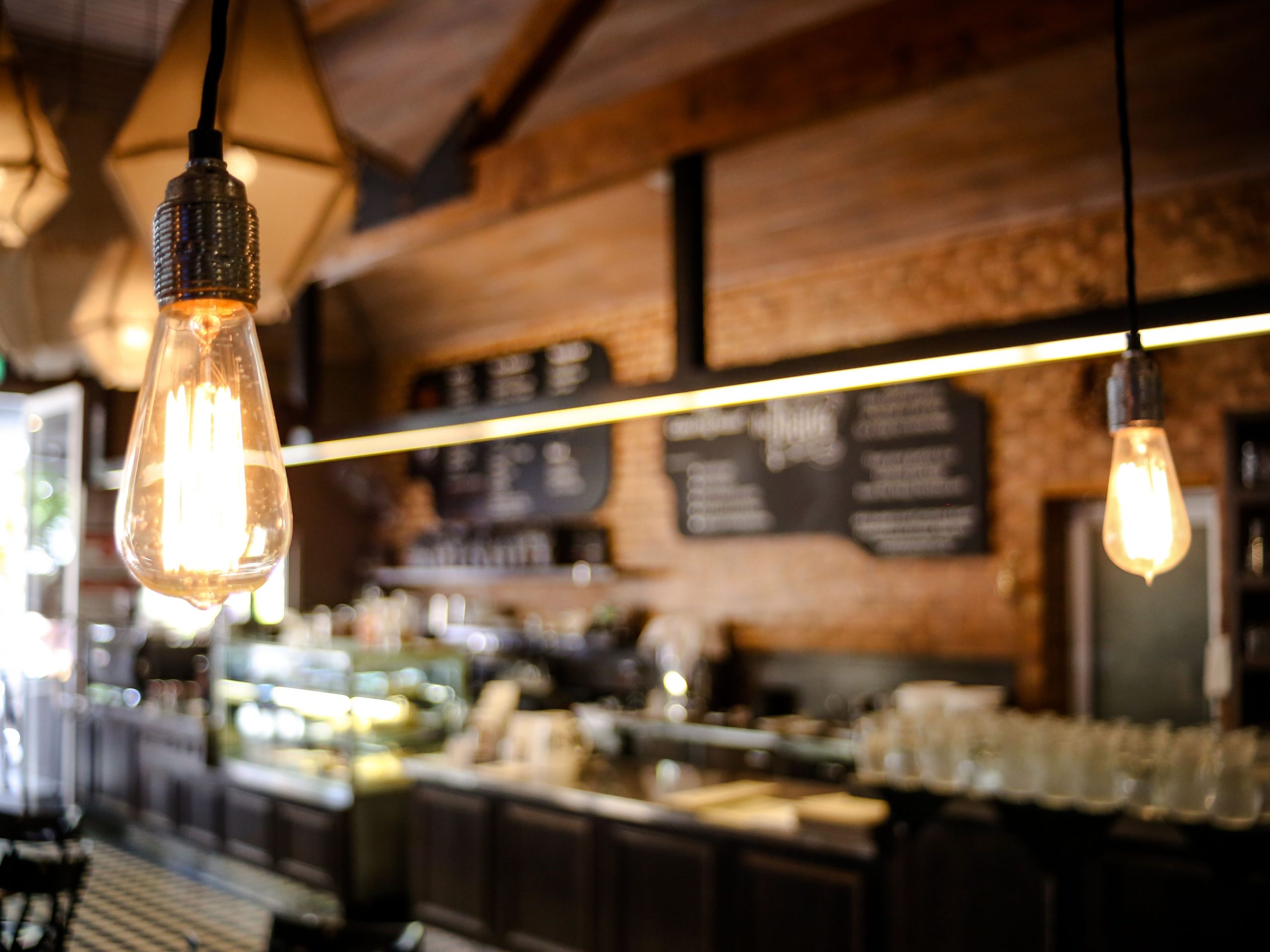 Ambiance chaleureuse café ampoules vintage comptoir flou