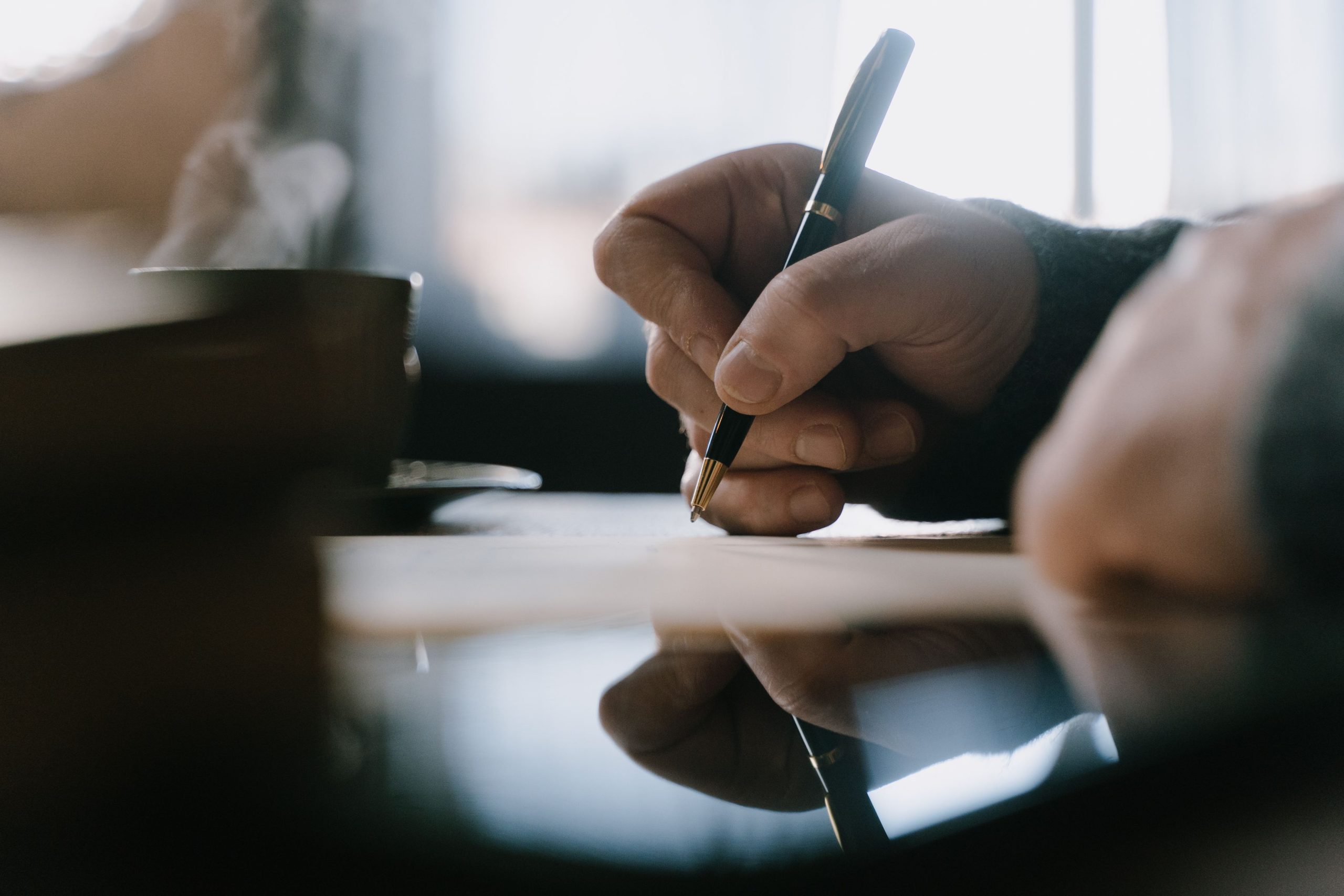 Main écrivant dans un carnet de notes