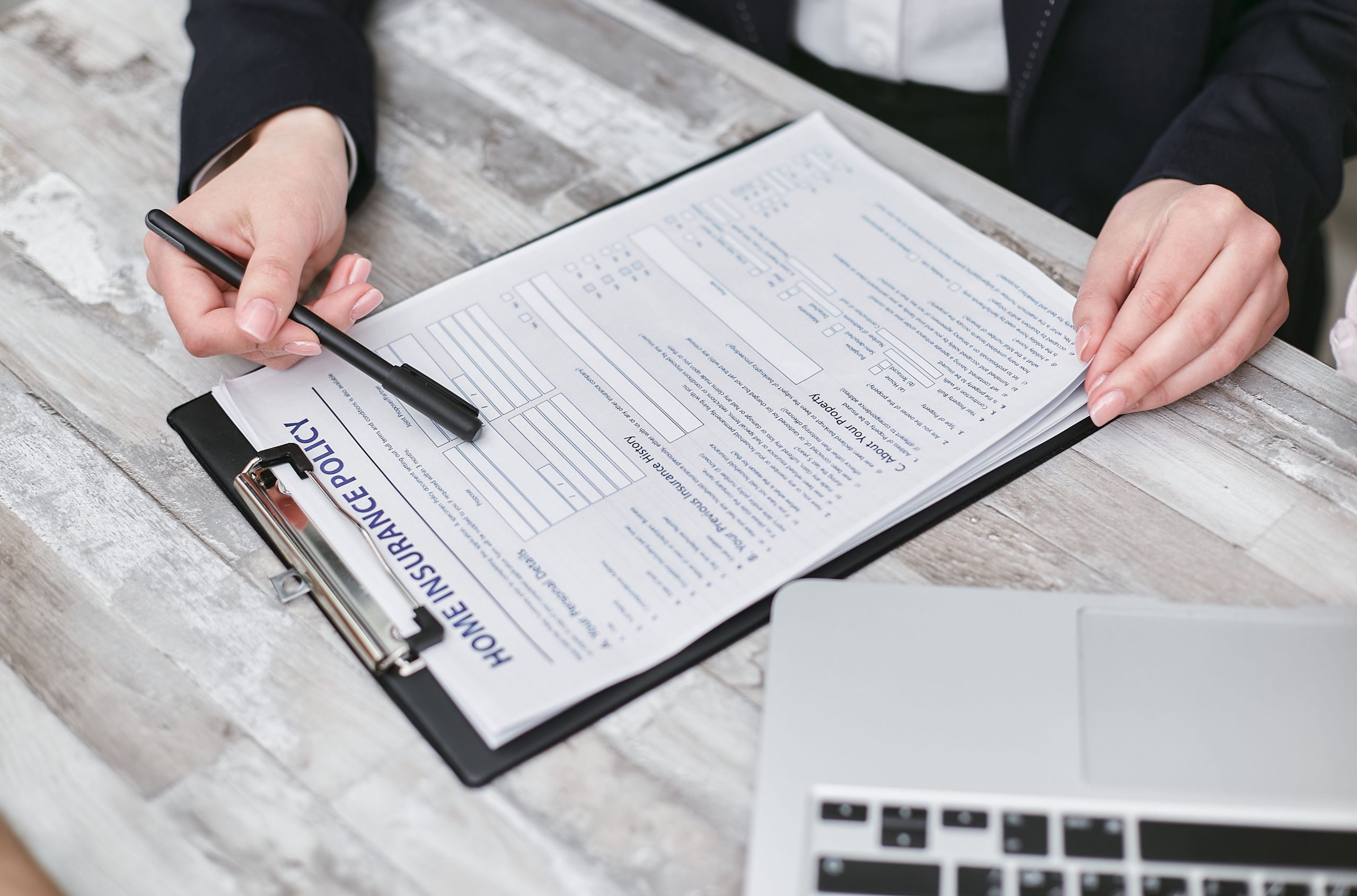 Mains examinant une police d'assurance professionnelle