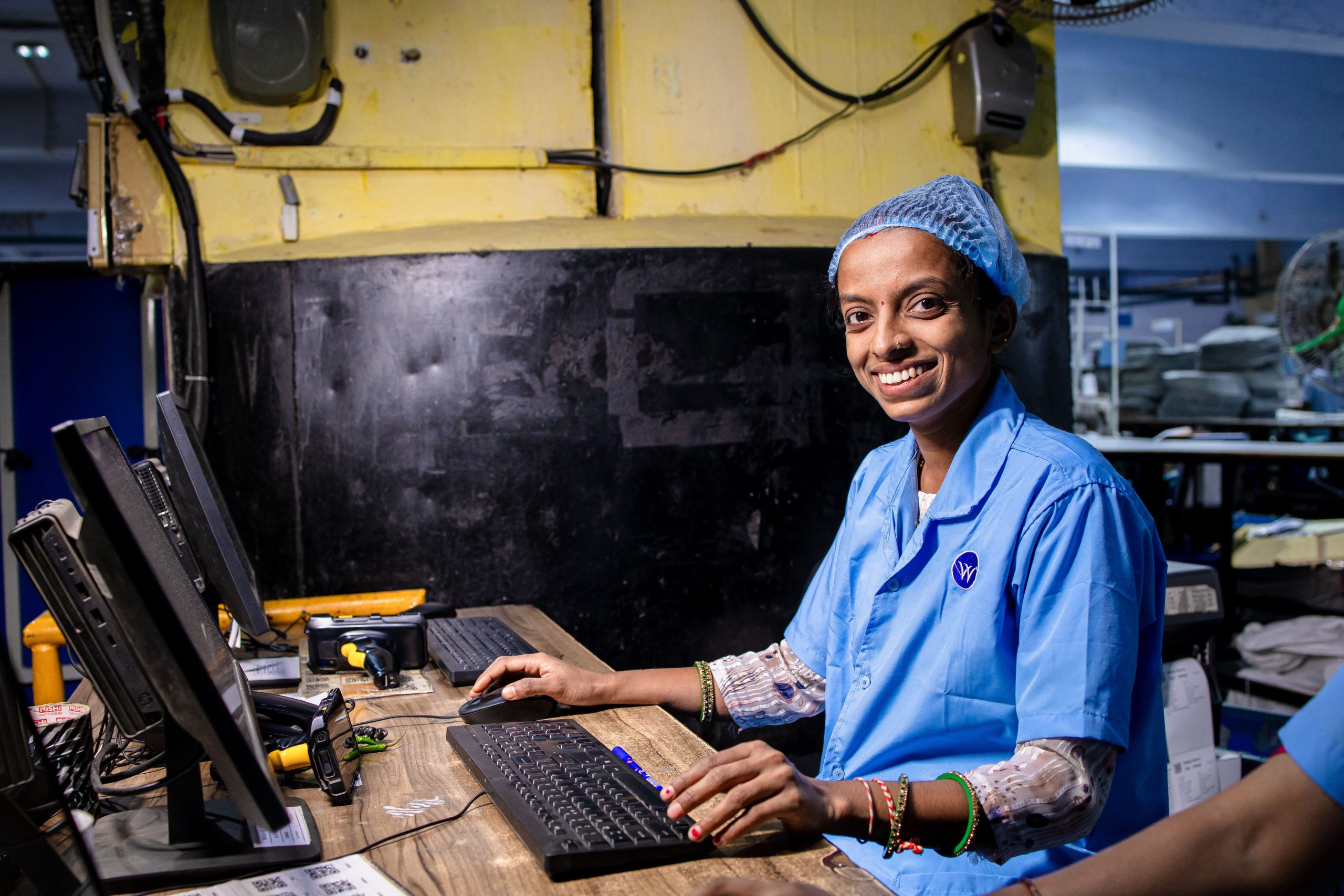 Ouvrière souriante opère ordinateur industriel