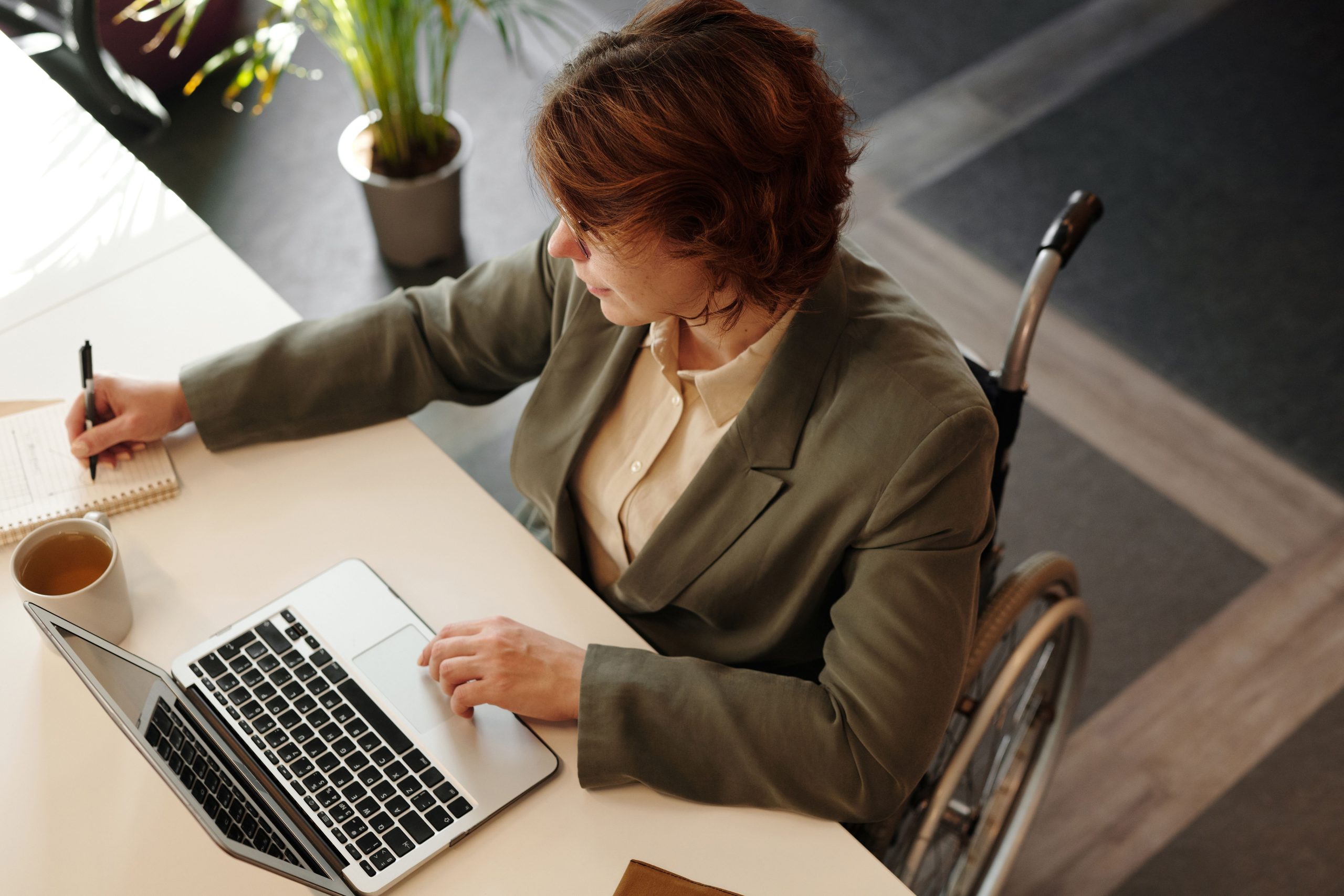Femme d'affaires en fauteuil travaillant à son bureau