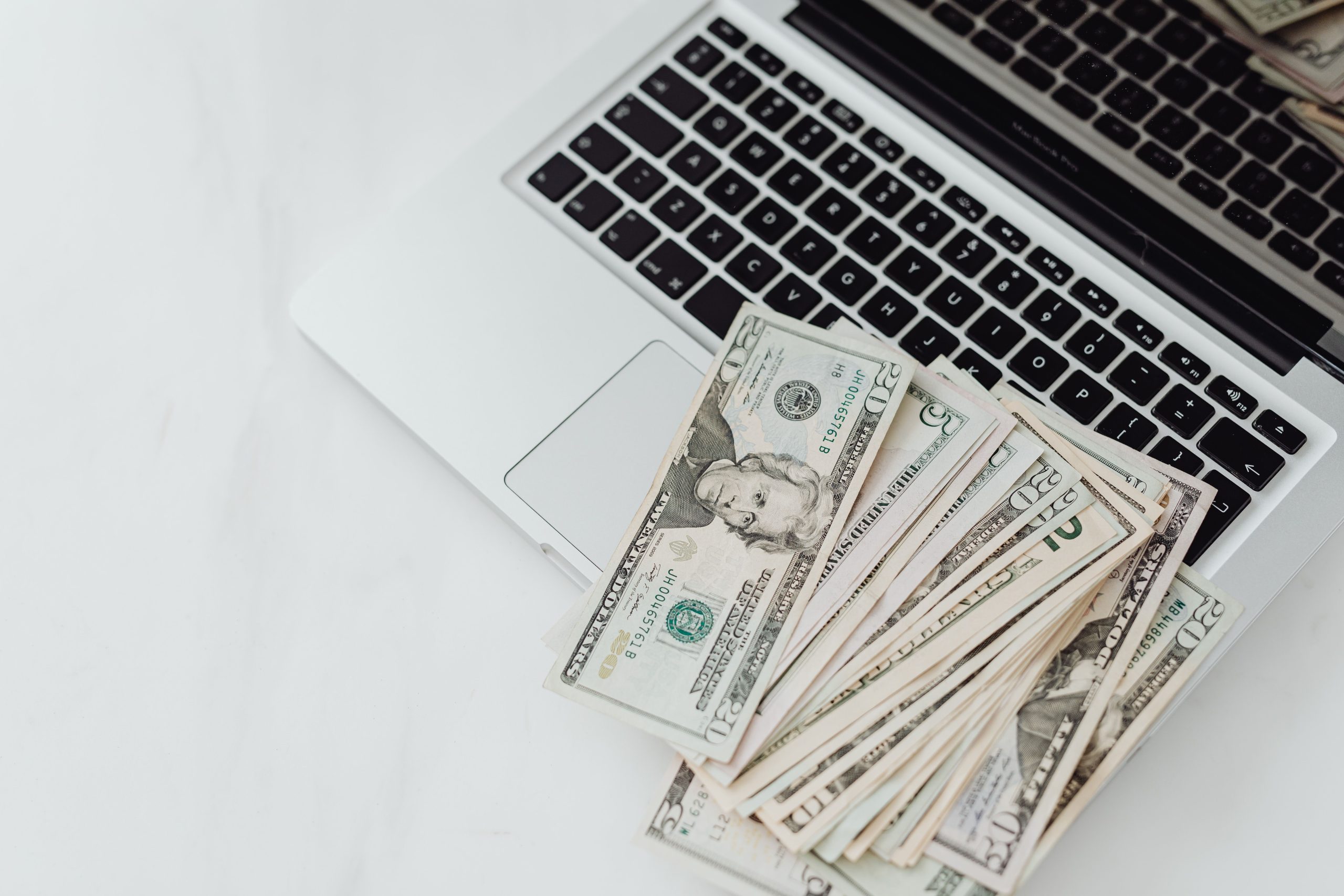 Billets de banque posés sur un clavier d'ordinateur