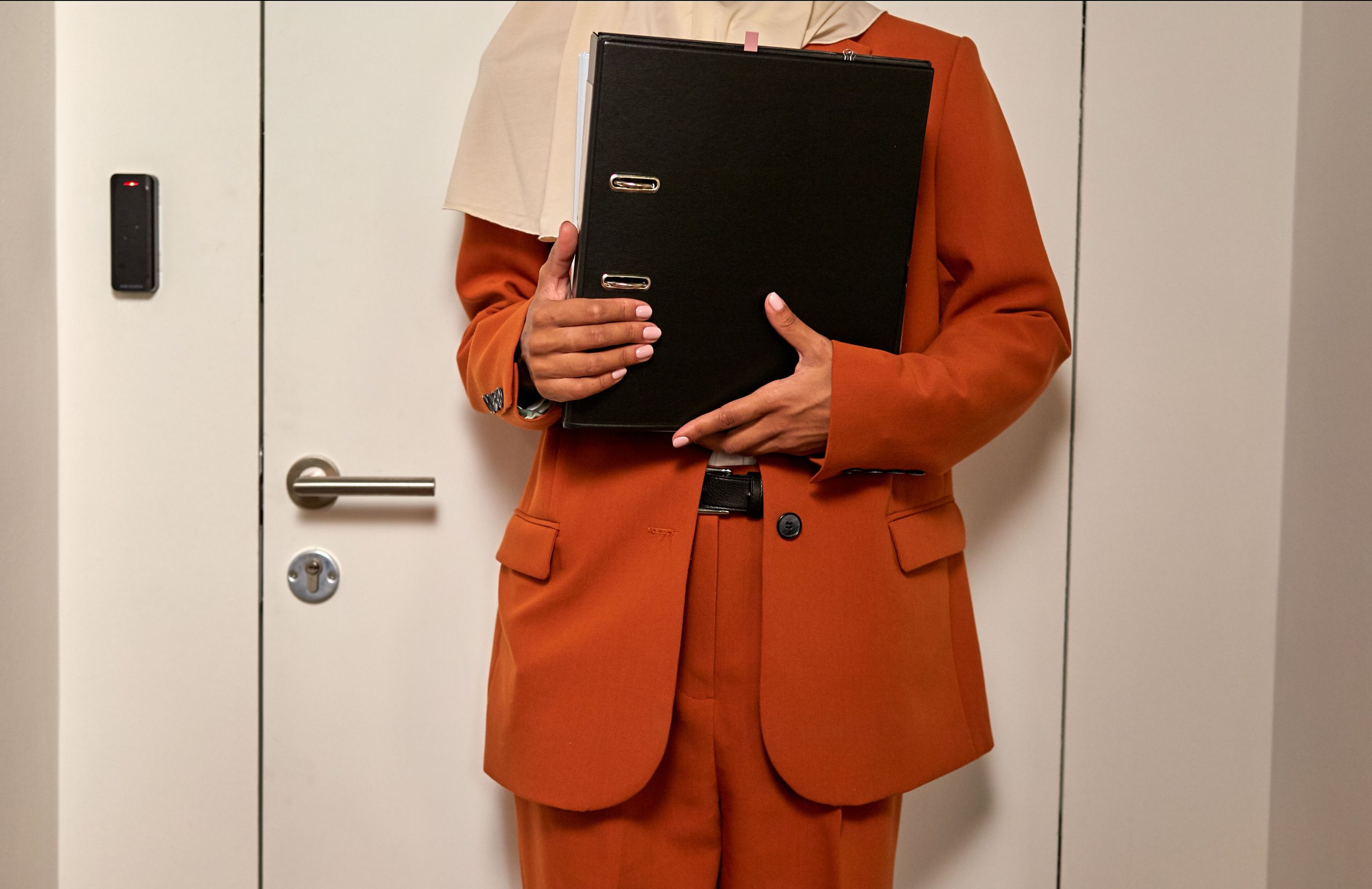 Femme en costume orange avec documents professionnels