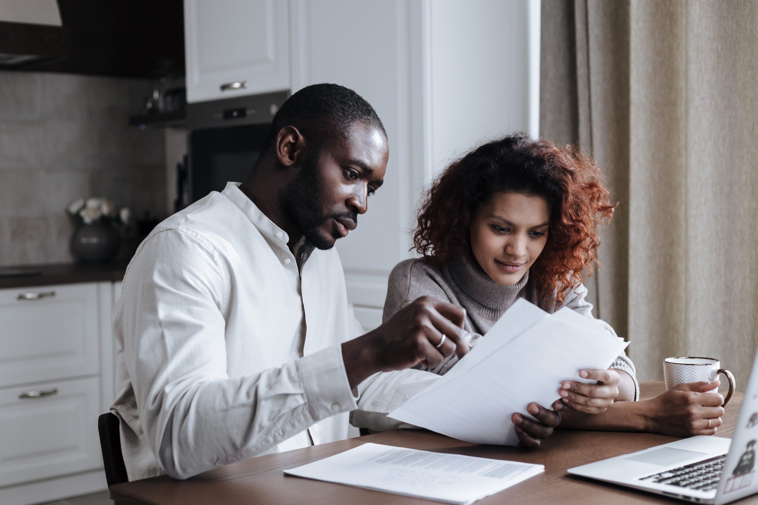 Couple travaillant sur des documents avec un ordinateur portable