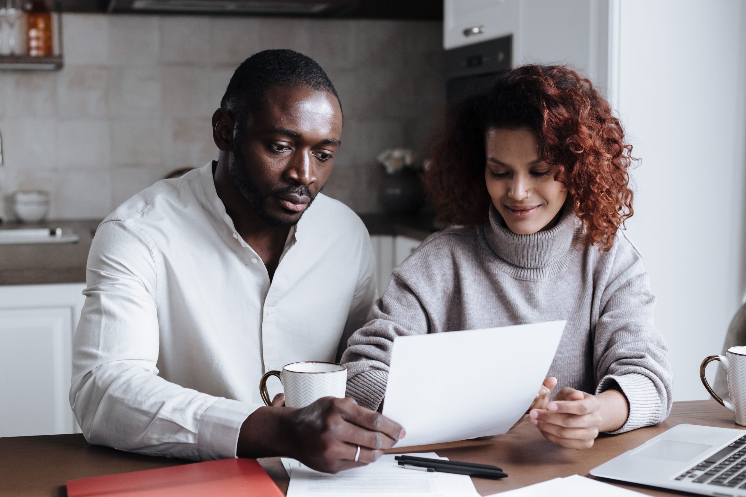 Couple qui examine des papiers à table en équipe