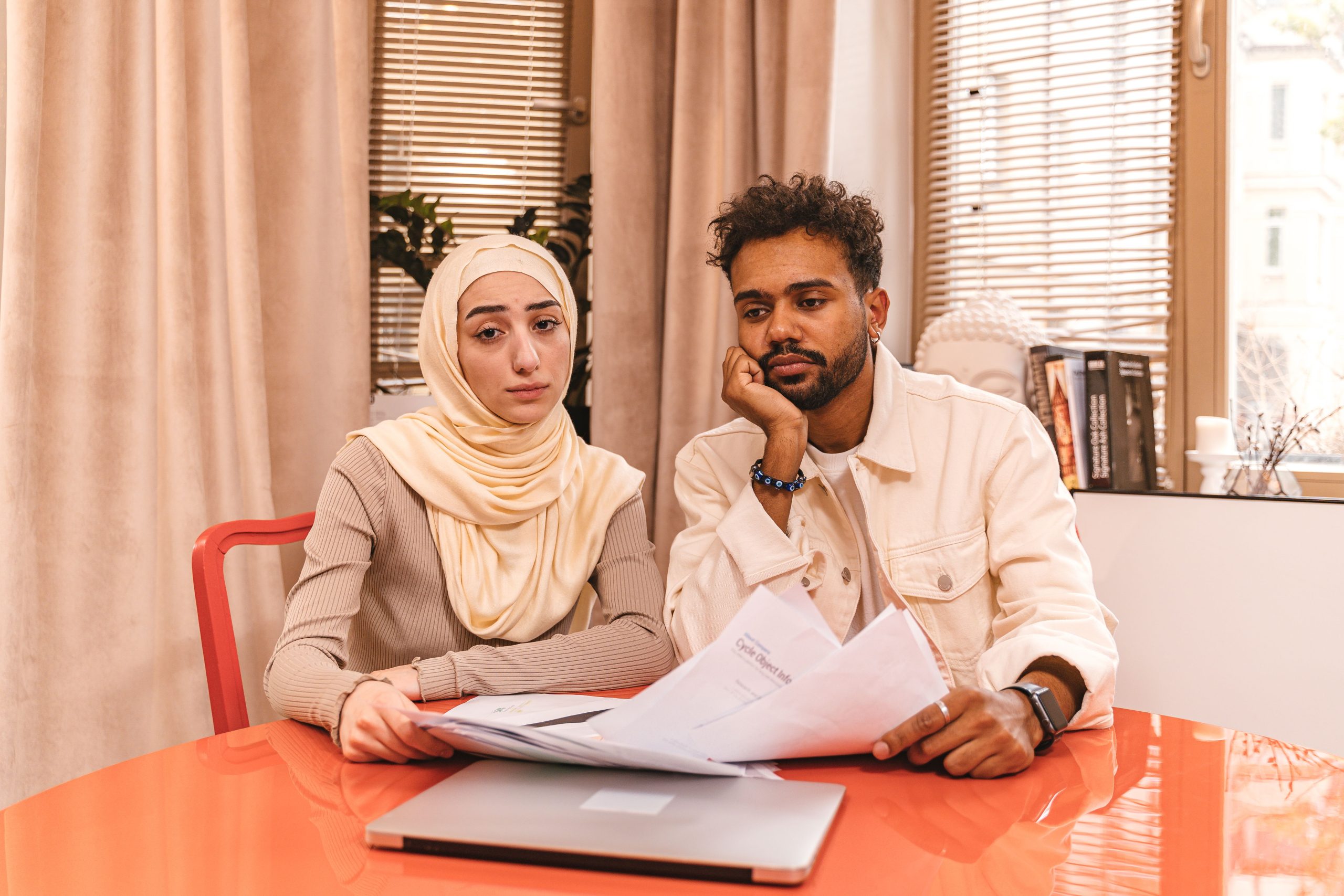 Couple assis consultant des documents financiers avec un ordinateur