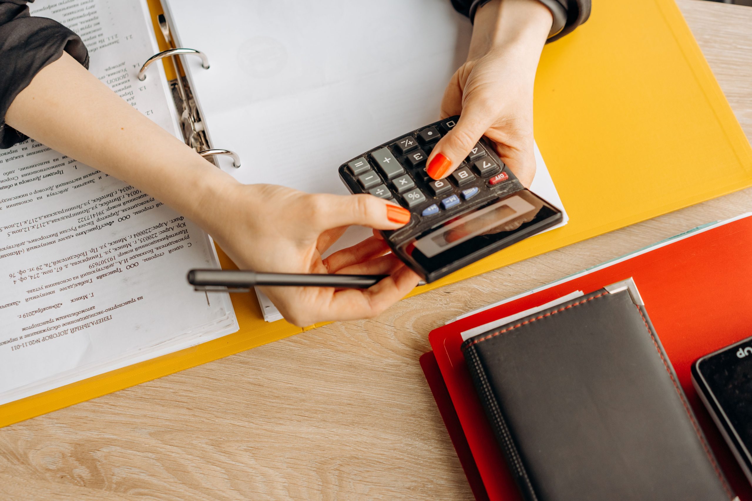 Mains utilisant une calculatrice près de dossiers