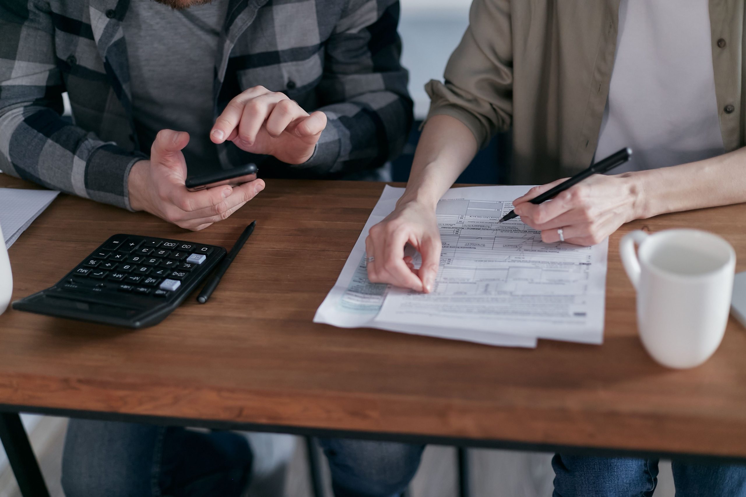 Deux personnes remplissant formulaires impots ensemble