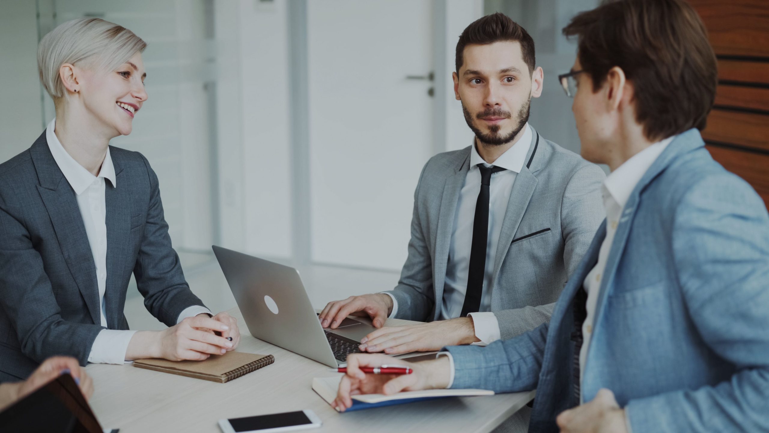 Professionnels en réunion avec ordinateurs portables