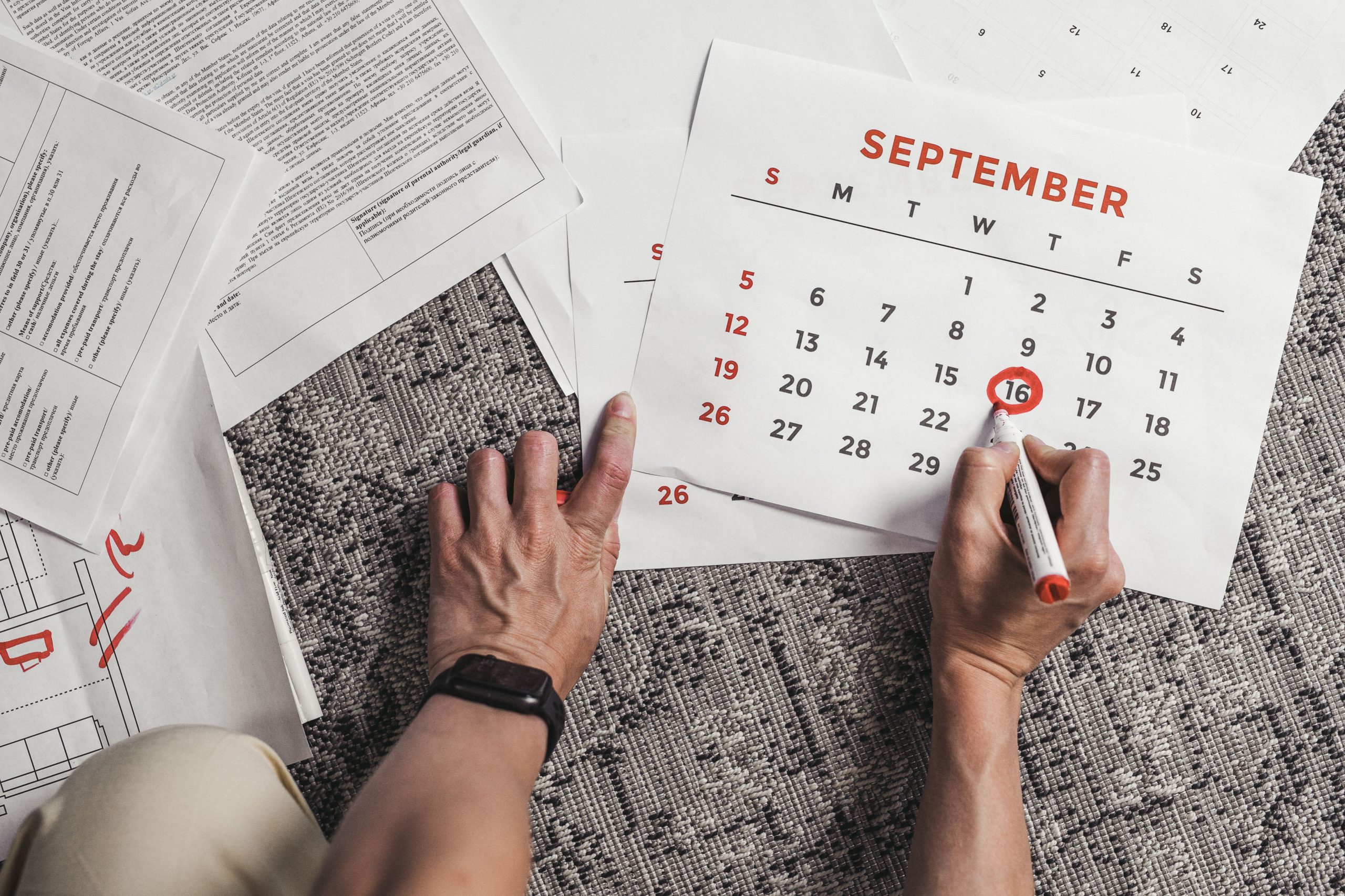 Mains tenant un calendrier avec dates entourées
