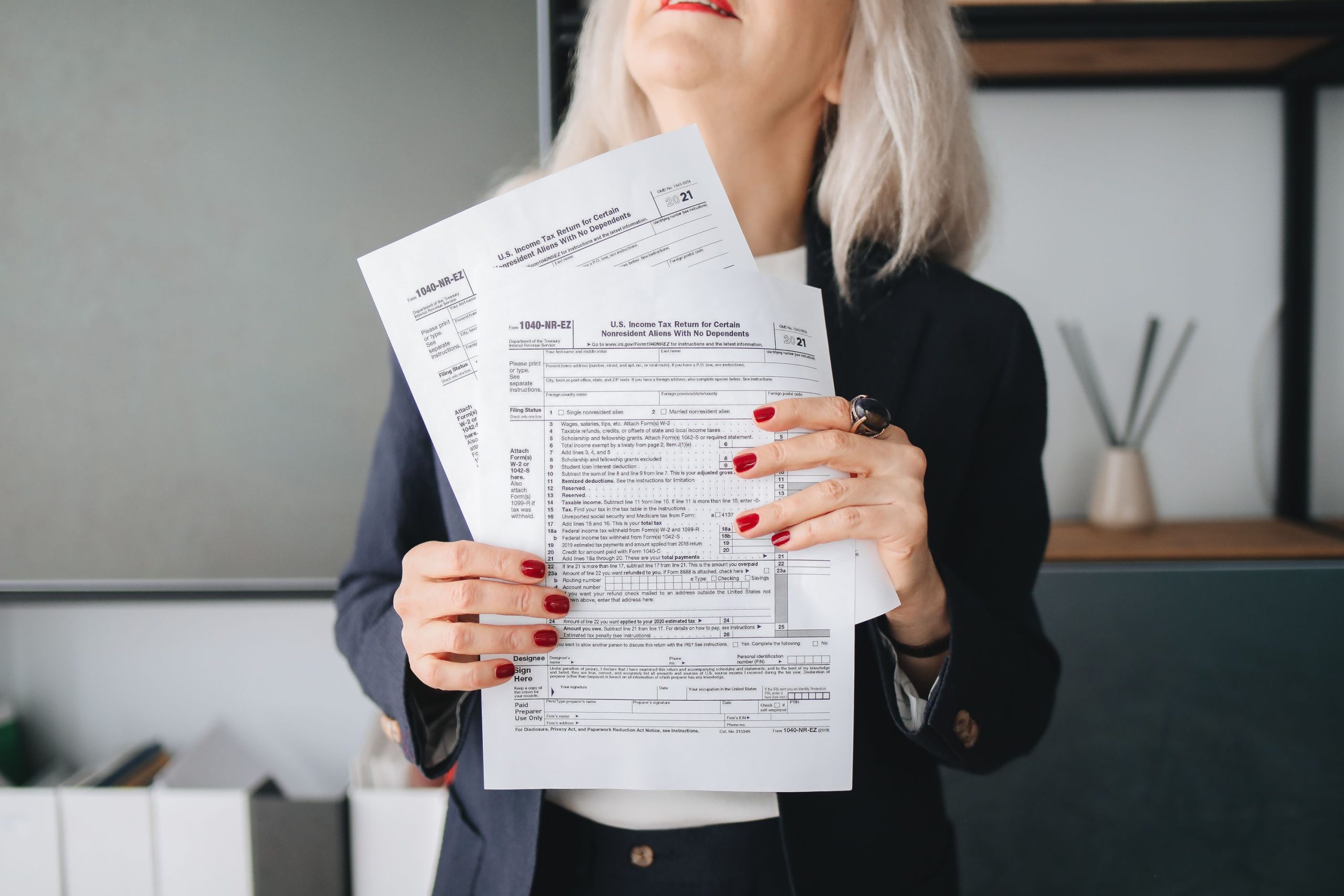 Femme tenant documents impots pour declaration