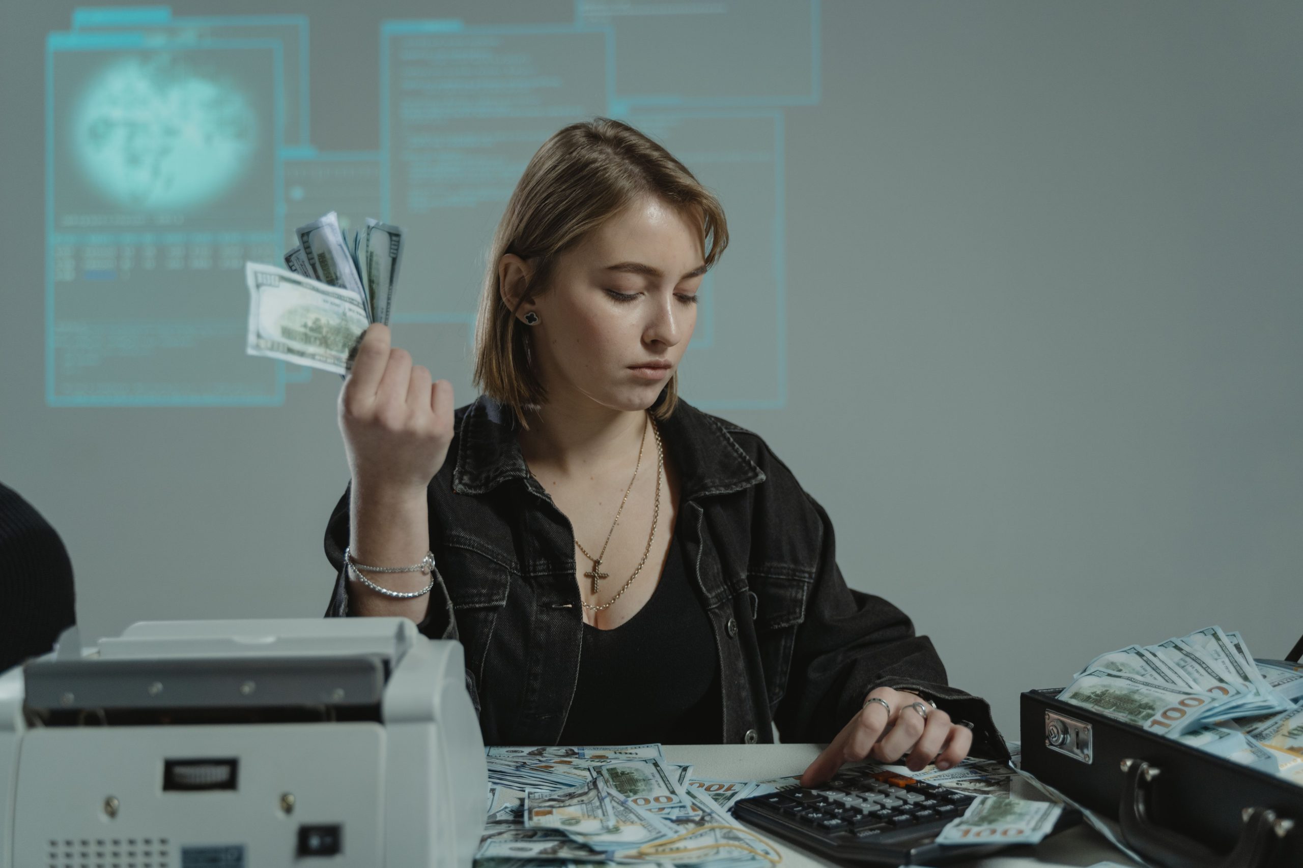 Femme comptant ses billets avec calculatrice
