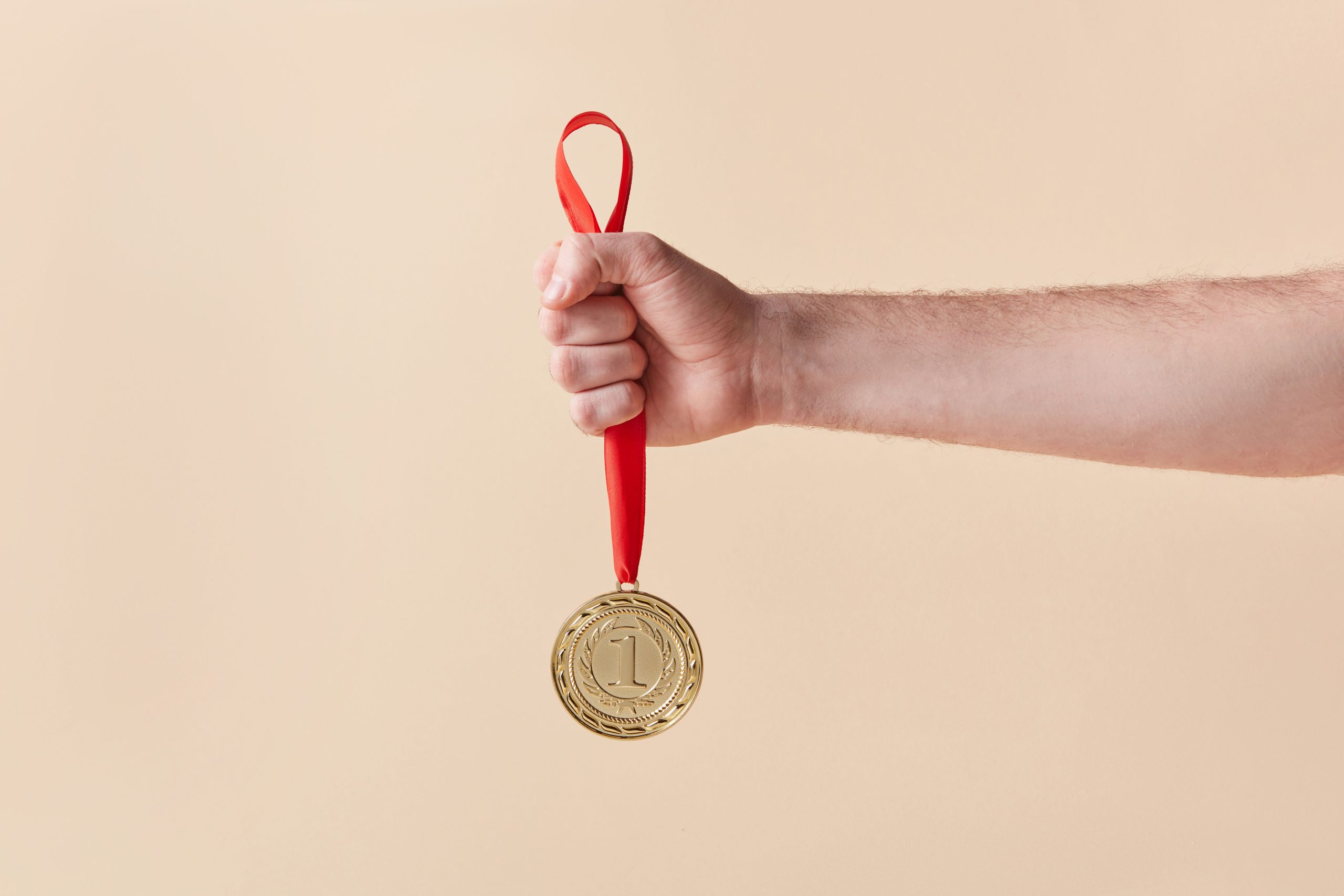 Main tenant fièrement une médaille d'or avec ruban