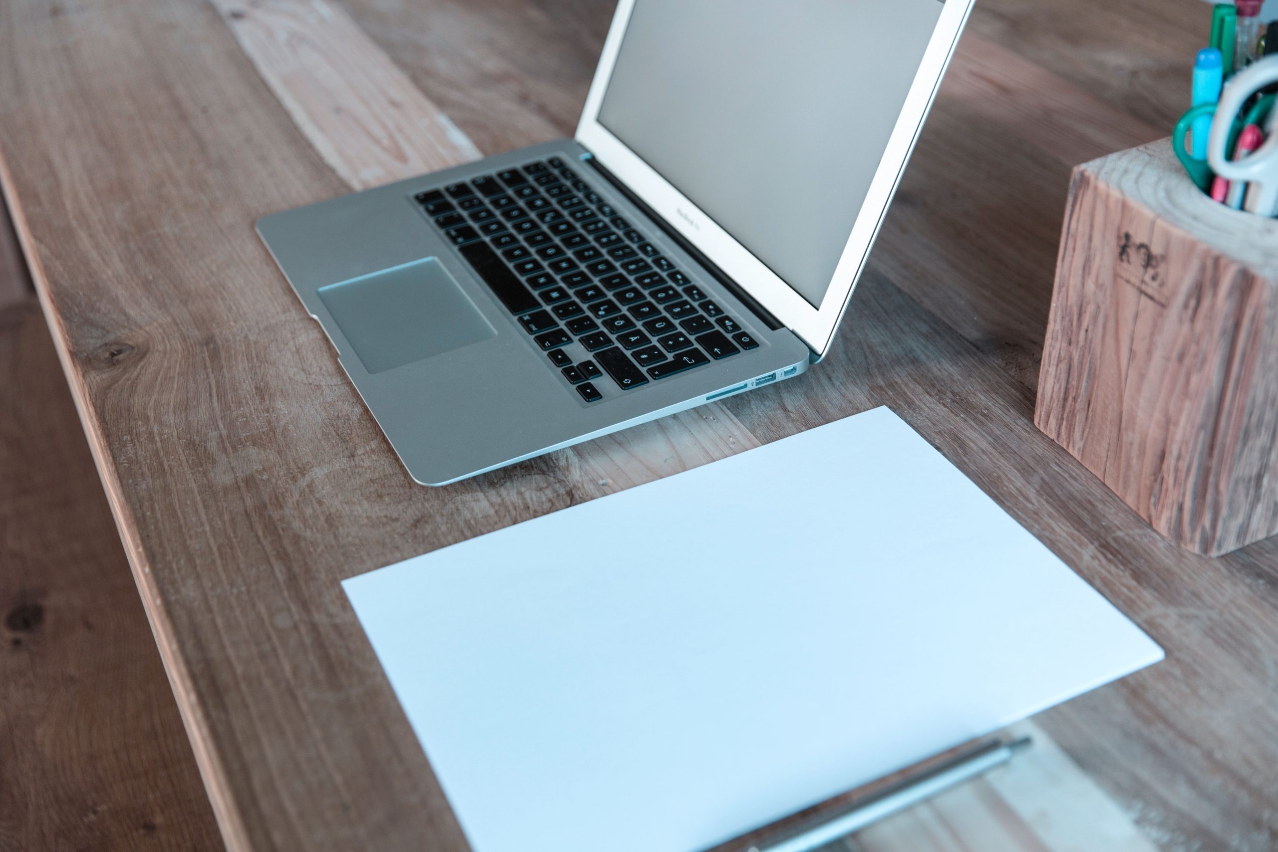 Bureau organisé avec ordinateur portable, papier et stylo