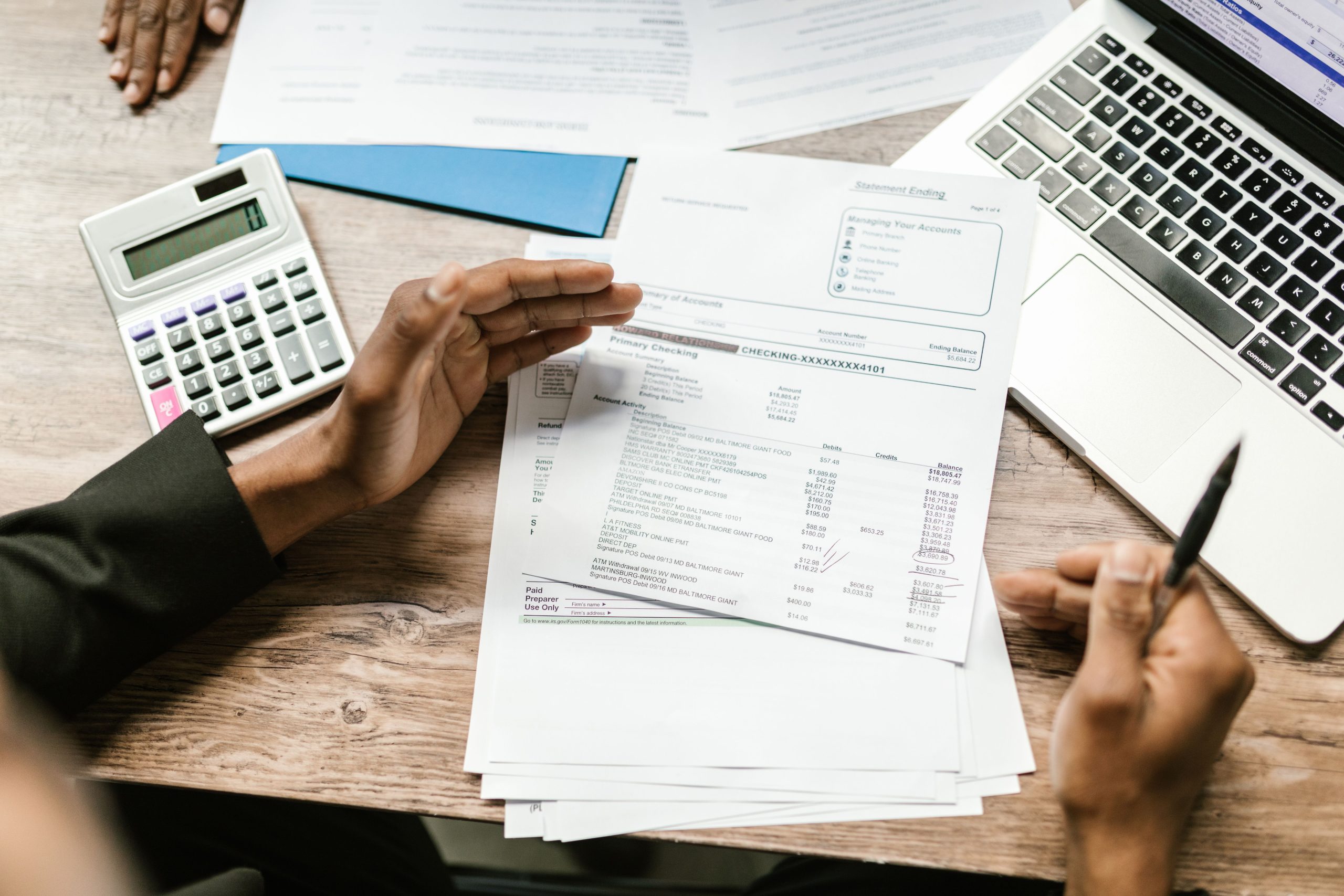 Documents financiers avec calculatrice et ordinateur portable sur un bureau