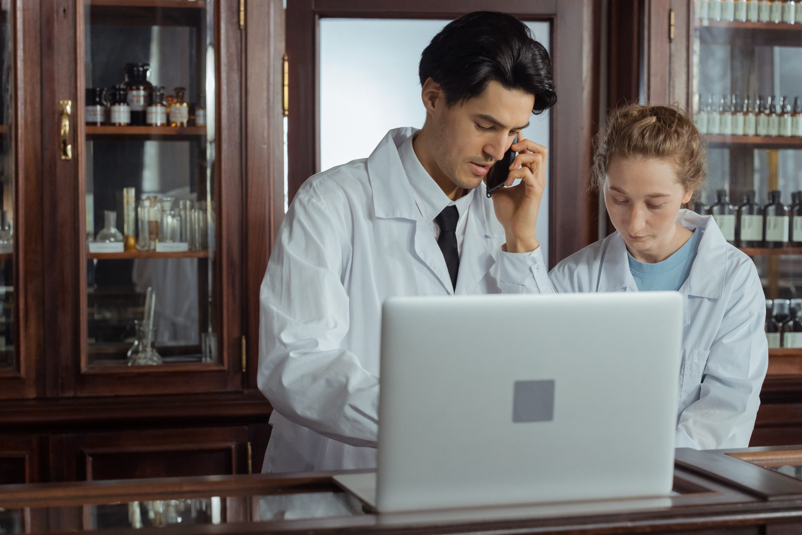 Deux pharmaciens collaborant avec ordinateur et téléphone