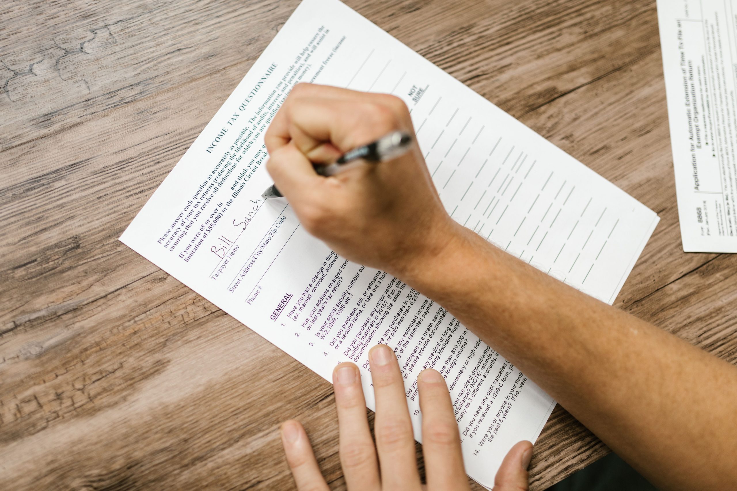 Personne complétant questionnaire fiscal avec stylo