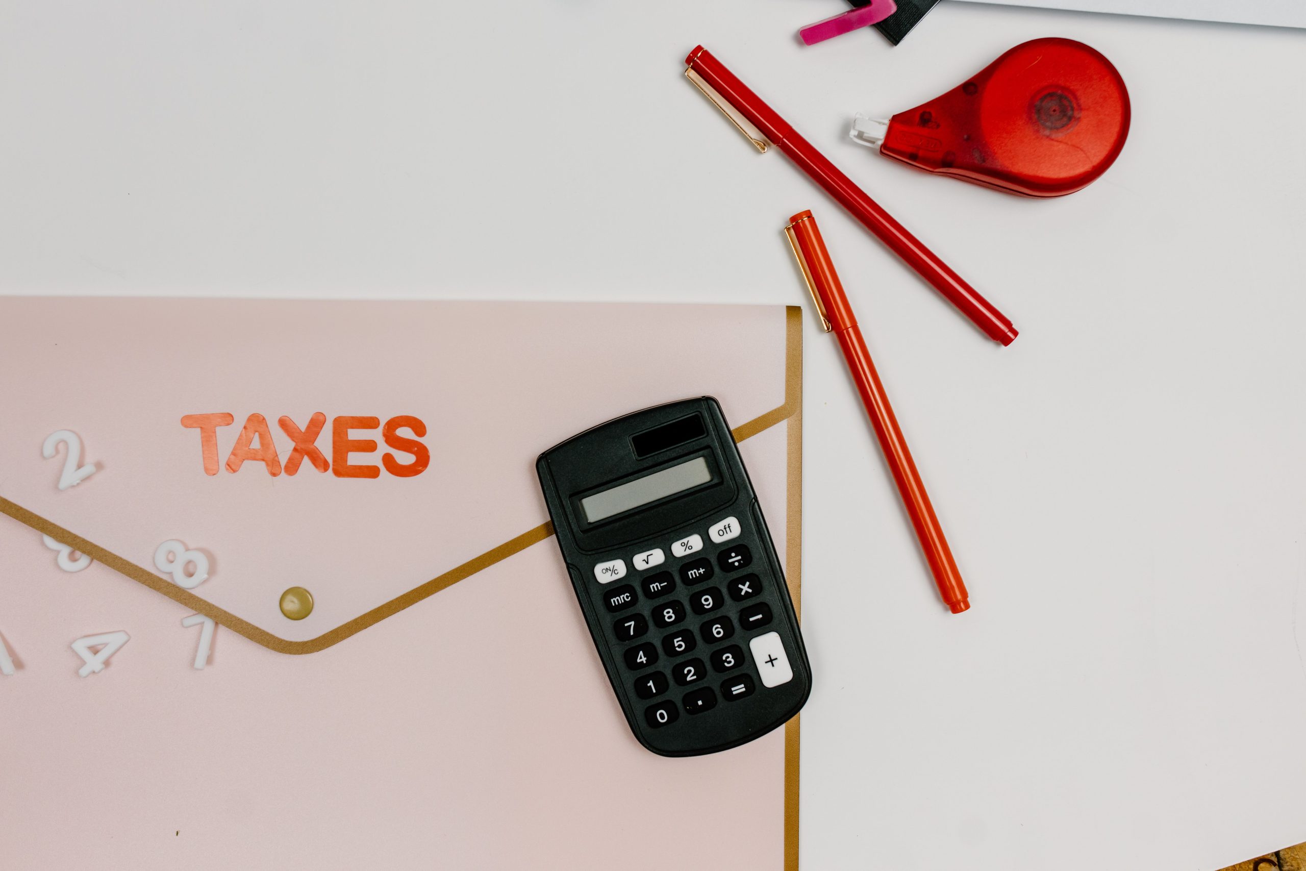 Calculatrice stylos et dossier taxes à plat
