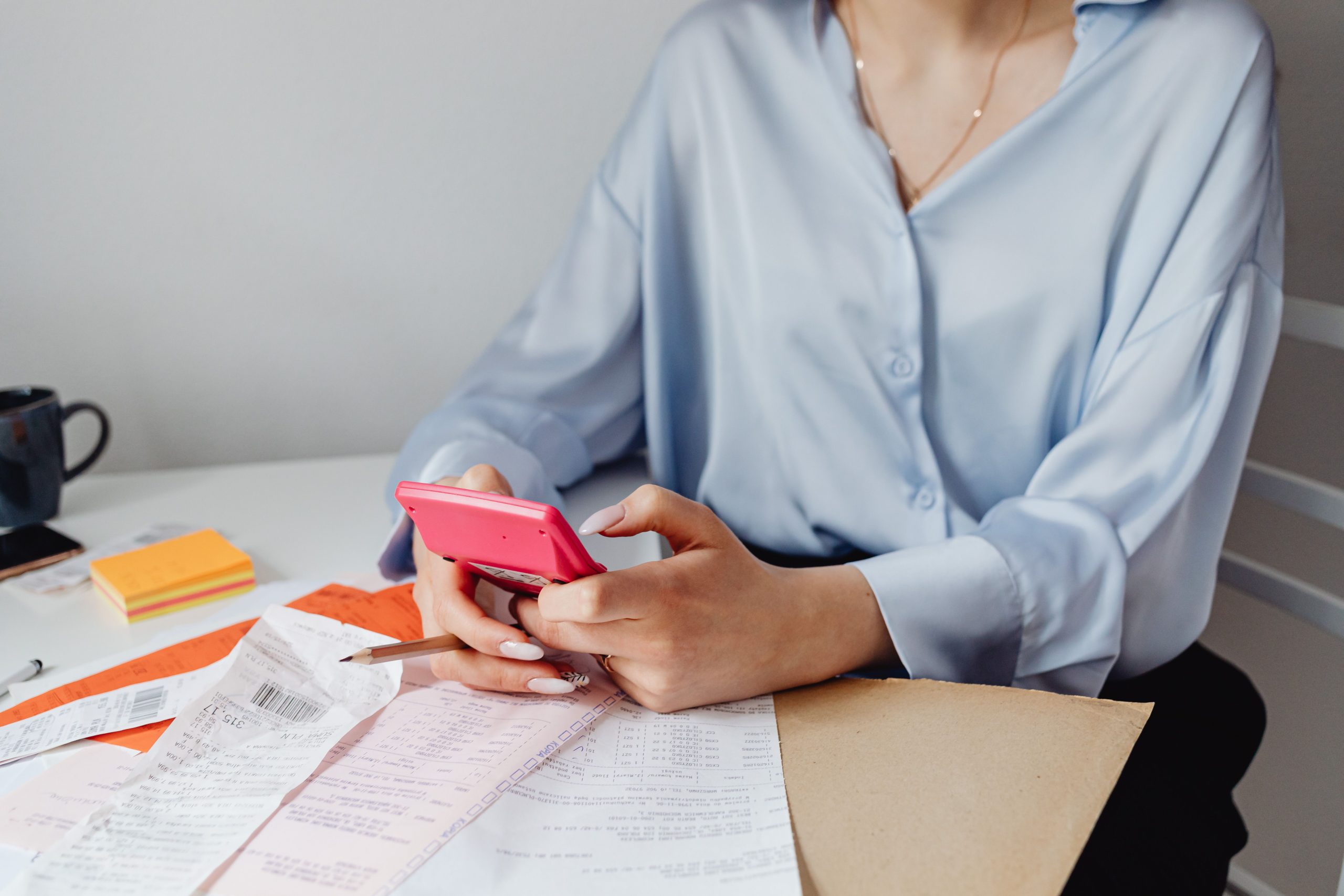 Femme calculant ses dépenses avec factures